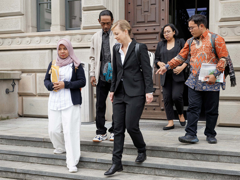 Die Kläger:innen Ibu Asmania und Arif Pujianto verlassen nach der Hauptverhandlung gemeinsam mit Ihrer Anwältin Cordelia Bähr das Parlamentsgebäude. (Foto: Daniel Rihs)